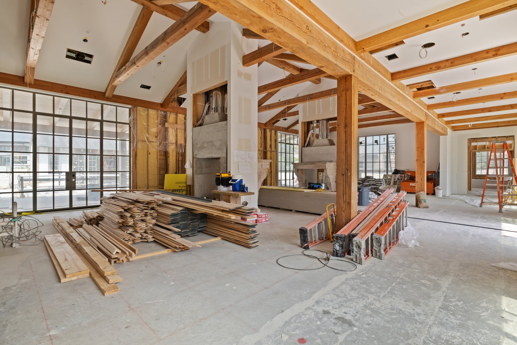 New construction great room with exposed beams and unfinished interior details