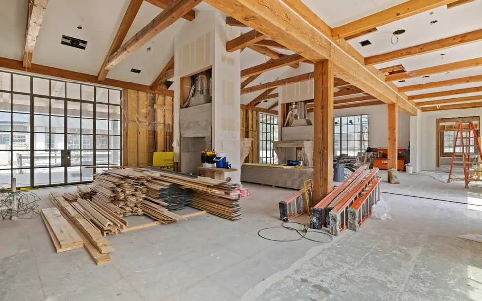 New construction great room with exposed beams and unfinished interior details