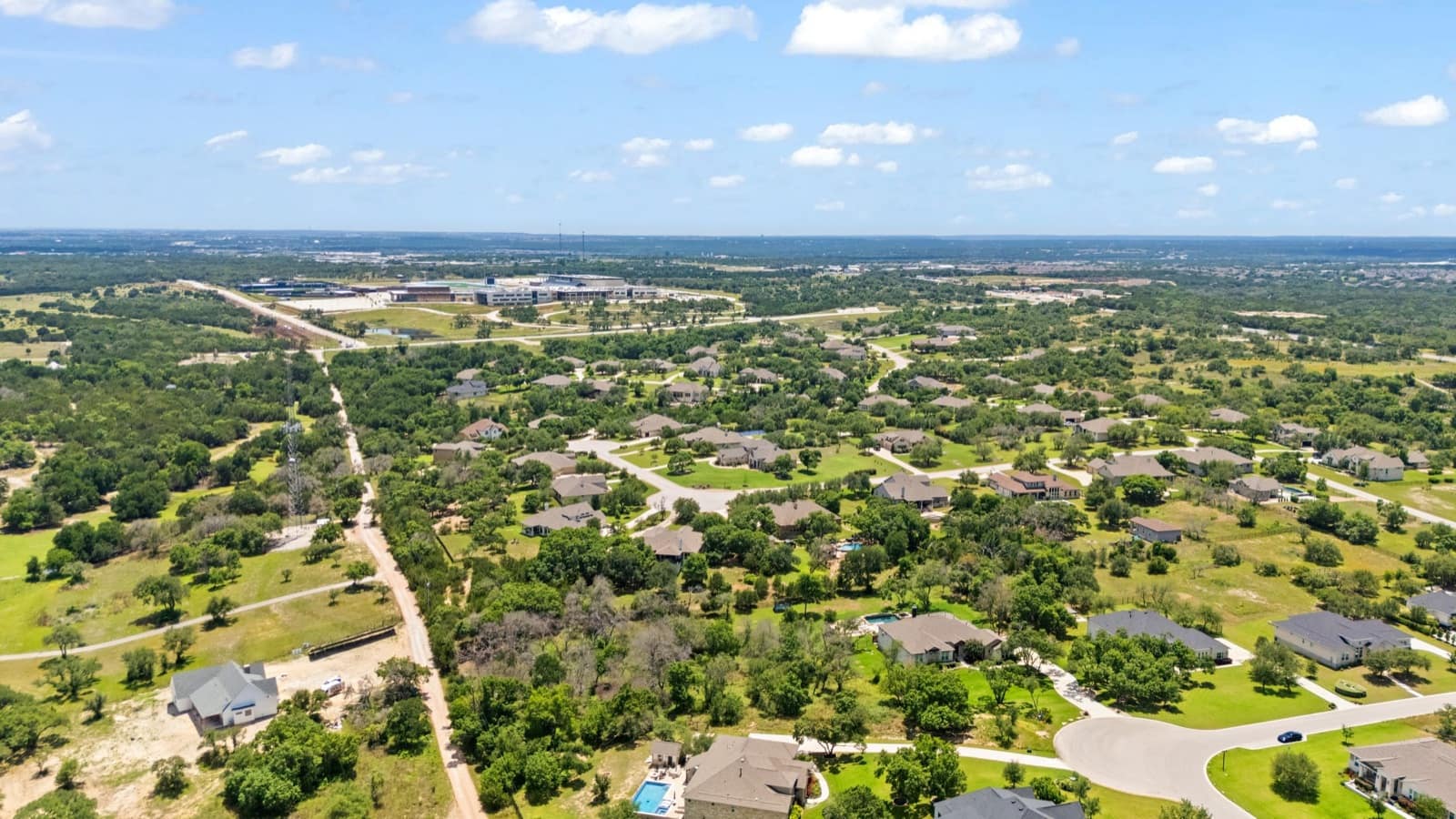 Wide aerial view of communities and open land north of Austin