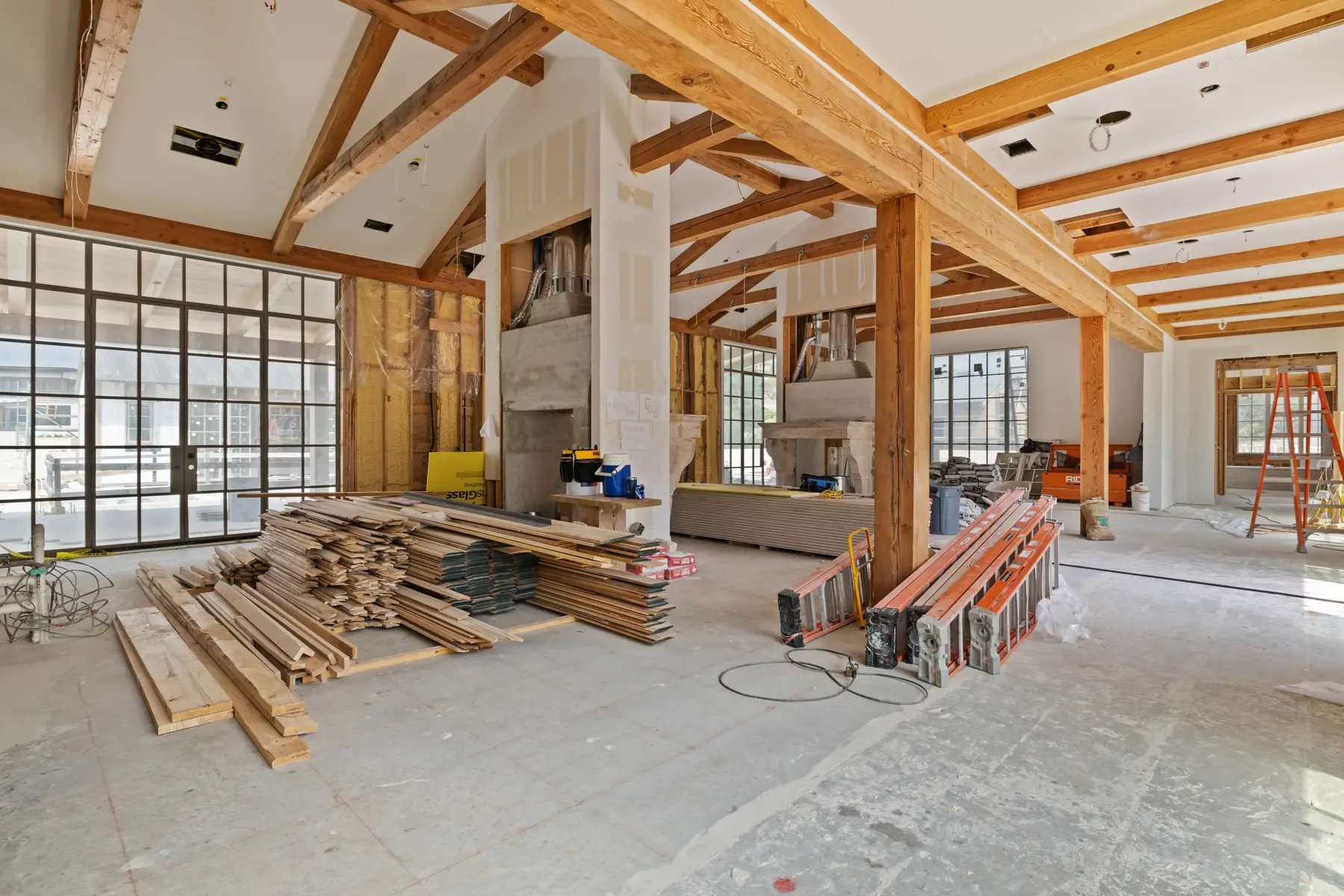 Leander-area new construction living room with exposed beams and finish work in progress